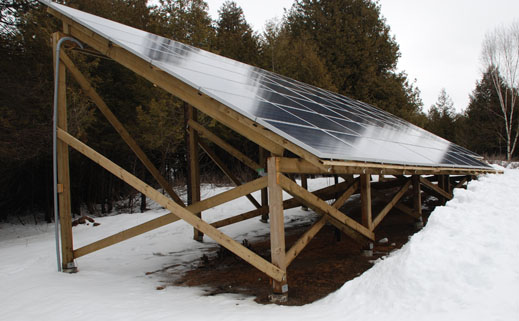 A picture of a 12 kW ground mount in winter, with snow melting